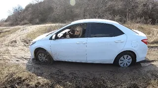 Blonde stuck in deep mud and pushing the car