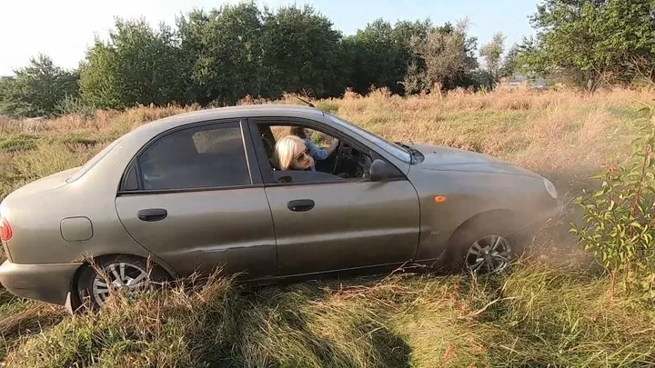 Girls driving over high grass and getting stuck