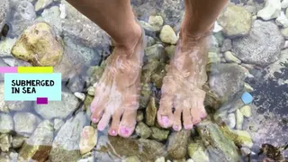 Big feet submerged in sea