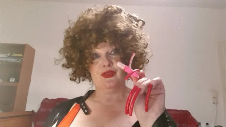 woman with Curly brown hair with long fingernails sucks a lollipop in form of a lipstick