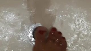 Exotic feet with painted toes playing footisies with water faucet