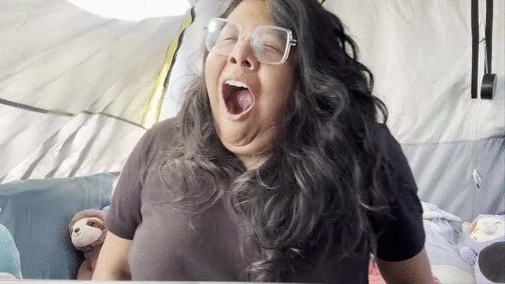 Yawning while camping in a tent