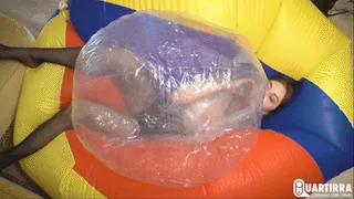 Q339 Leya blows and deflates clear beachball while lying on a giant one