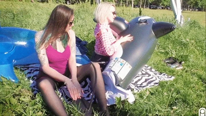 Q127 Leya uses a foot pump to inflate a black Orca under Lilu outdoors