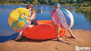 Q886 Cosette and Stashia blow two big beach balls on a lake