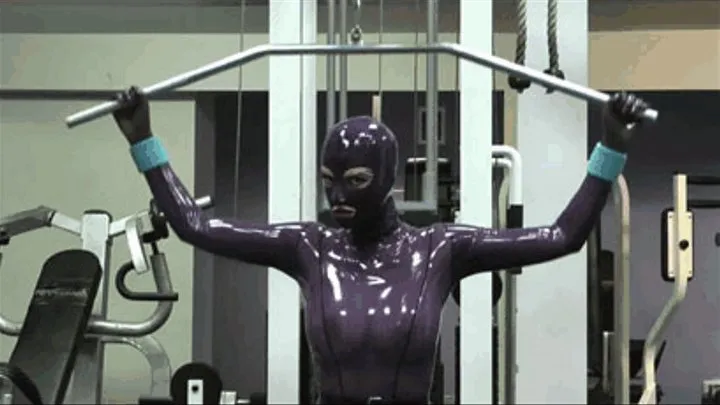 Hot blonde girl in gym makes fitness in purple rubber latex catsuit