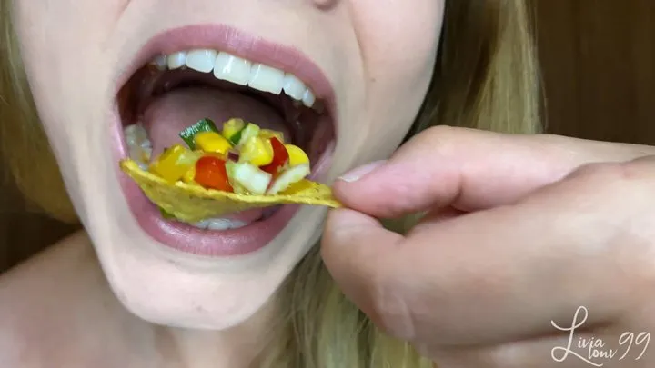 Colorful salad with nachos closeup chewing