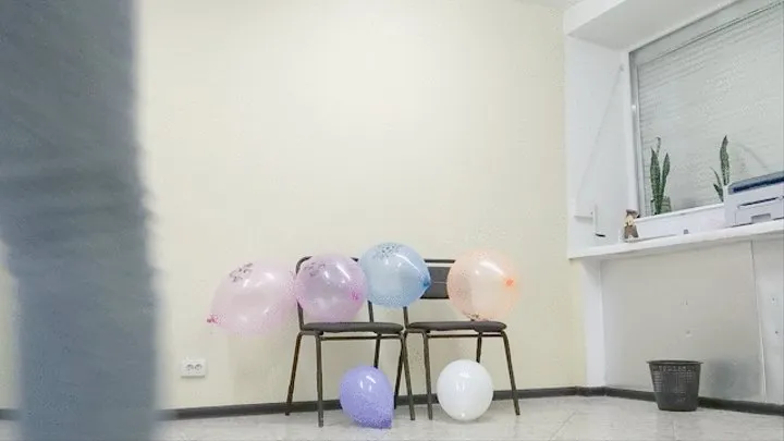 The girl in the office has fun with balloons