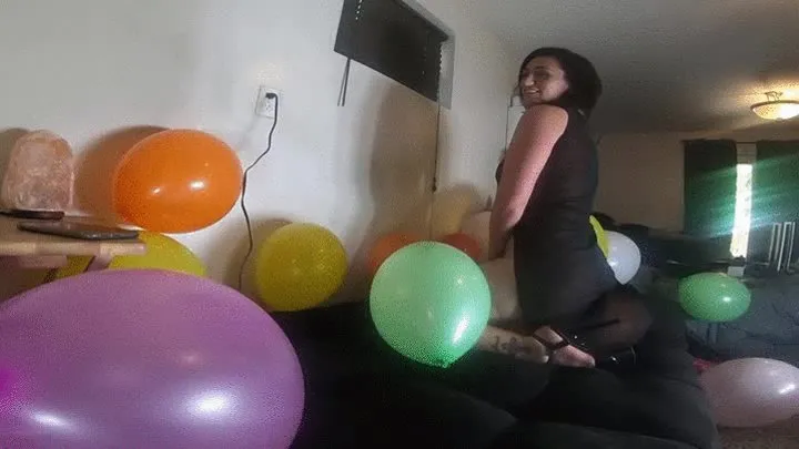 Chloe sitting and stomping inflated balloons 2 angles