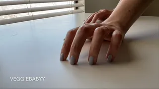 tapping polished nails on a white table