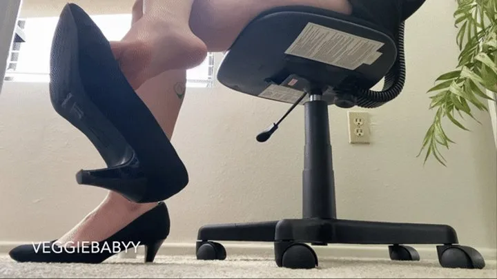 secretary dangles black heels in the office