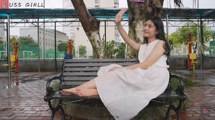 Mature and intellectual female music teacher Wei Wei wears a long skirt and shows her beautiful feet contentedly on the campus bench