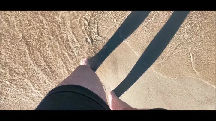 Playing with feet on a beach in wet sand