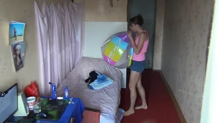 Svetlana is in a hurry to inflate a beach ball