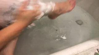 lady shaves legs in the bath