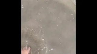 Barefoot in cold beach water
