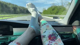 FEET ON A CAR DASHBOARD