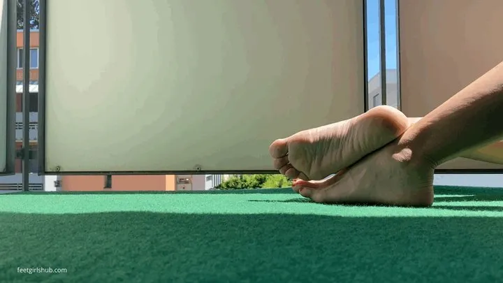 SUNBATHING FEET ON A BALCONY