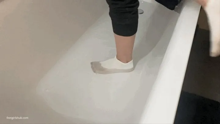 DIRTY WET SOCKS WASHING IN A BATHTUB