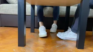 TWO STUDENTS FOOTSIE IN A LIBRARY AND SHOE STEPPING