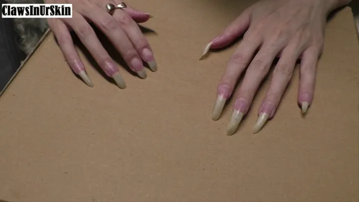 sharp nails scratching and piercing cardboard hard
