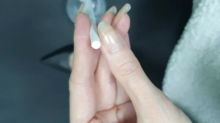 Holding a cigarette, not smoking