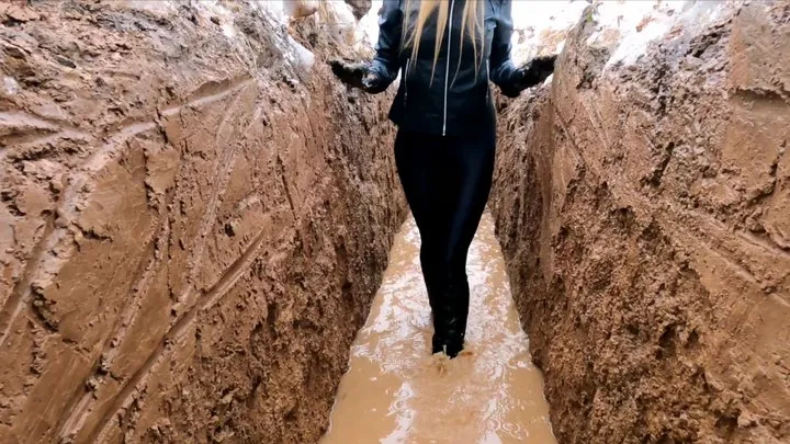 Sexy girl in leather clothes walks through deep soft mud in high heel boots