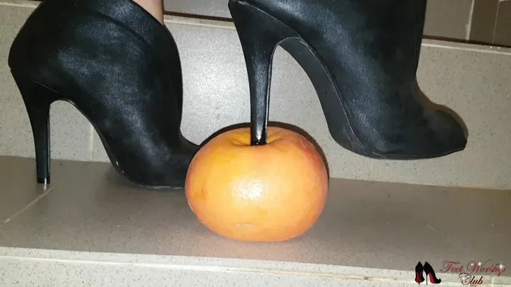 High heels boots crushing a grapefruit