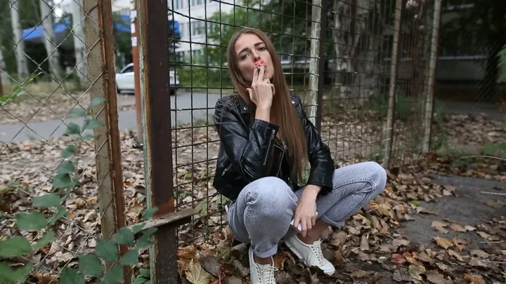 Natasha smokes outdoors