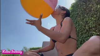 Akina blows up and plays with her beach ball at the pool