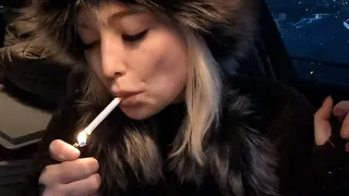 Smoking a cigarette in the car in the evening in winter