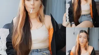Smoking in jean shorts and a white top no bra