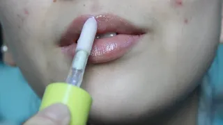 Aurora Lathers Lip Gloss Onto Her Lips