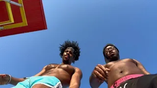 black men step on tiny man with sandy feet