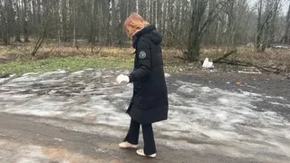 A girl walks in ballet flats on a very bad road where there is slippery ice and slippery mud, her ballet flats slip on such a road and get very dirty