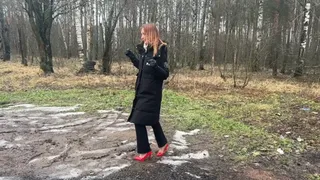 A girl in sexy high-heeled shoes deliberately decided to walk along a dirty forest path, dirtying her heels and destroying them