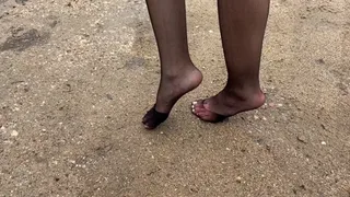 Girl in nylon stockings with pedicure she walks through the mud and the ground, her stockings start to tear and in the end she tramples them into the mud