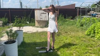 A girl in high-heeled shoes crushes wooden planks and makes holes in them