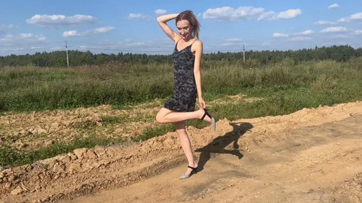 A girl in high-heeled shoes got lost and walked down a country road, her heel got caught and she twisted her leg