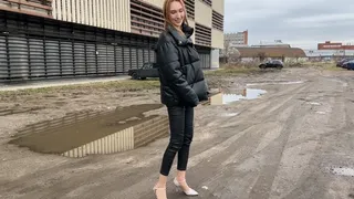 girl walks along a muddy road and gets her shoes and feet dirty