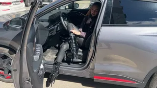 The girl in ballet boots wearing ballet boots, she presses the pedals of the car and plays with his extremely high heels