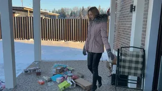 girl in high-heeled boots crushes cardboard and boxes and enjoys it
