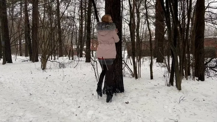 a girl walks through the winter forest in extremely high heels ballet boots