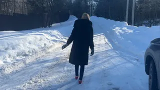 girl in ballet shoes walks along an icy road and slips a lot
