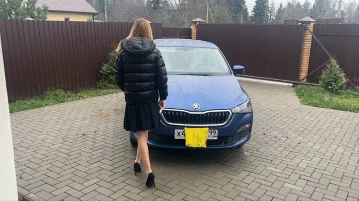 girl in stockings and high-heeled shoes plays with the pedals in her car, pressing the gas and listening to the sound of the engine