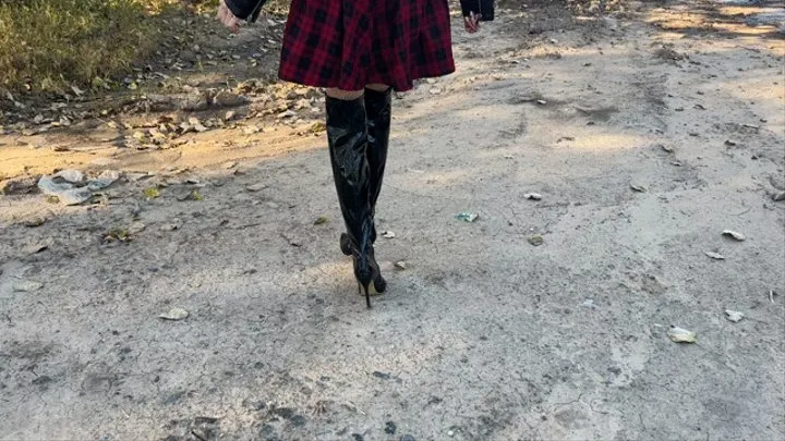 girl in high-heeled leather boots walks through very deep mud, which slowly pours into her boots