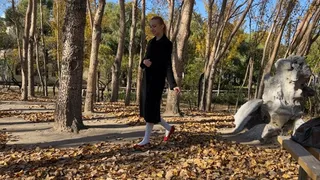 girl in white tights and ballet shoes has fun with fallen leaves, loses her shoes and gets her pantyhose dirty