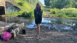 a girl in high-heeled boots walks through a swamp, mud and water are poured inside