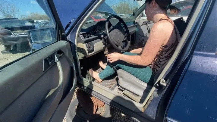 Barefoot pedal pumping in a dirty junk car