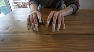 Long curved nails tapping and scratching table